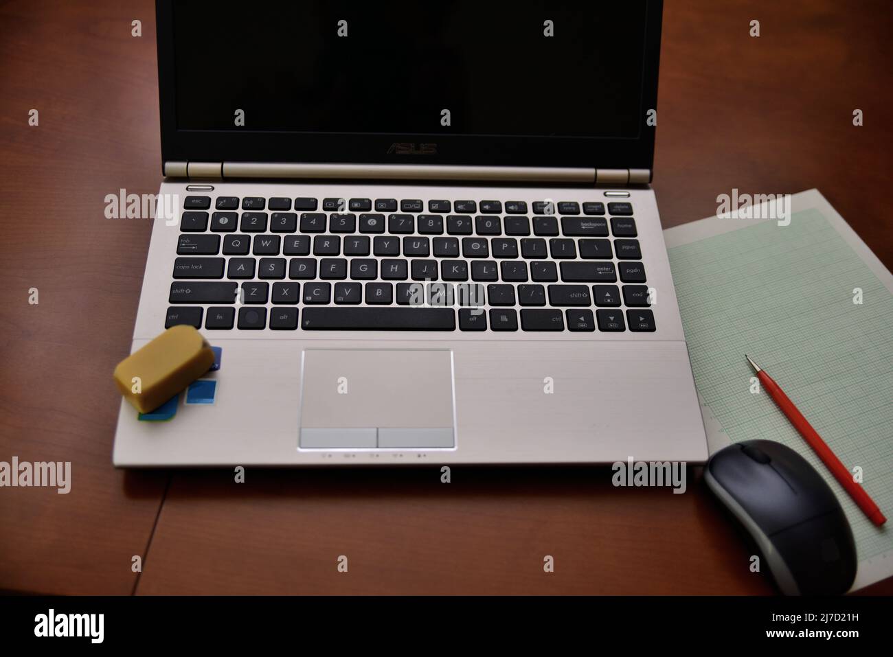 Laptop computer on a desk in a home office.with pencil and paper arranged for note taking. Eraser, too. Stock Photo