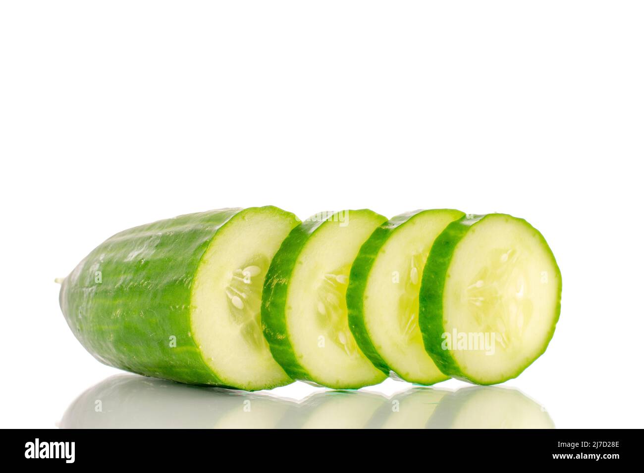 One half and three slices of juicy smooth cucumber, macro isolated on white background. Stock Photo