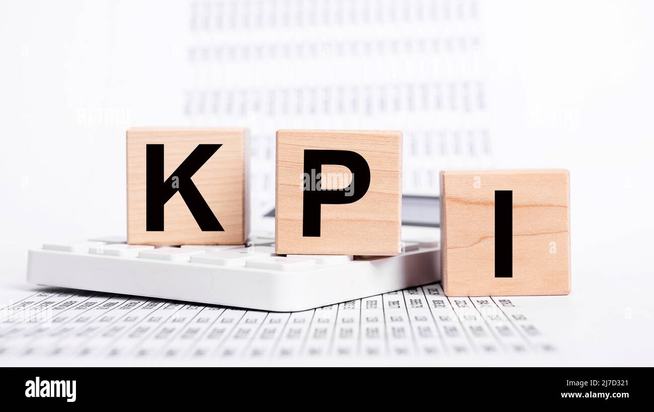 Key performance indicators. KPI letters at cubes, calculator and documents with statistics. Assessment of success at reaching business targets concept. Strategic planning. High quality photo Stock Photo