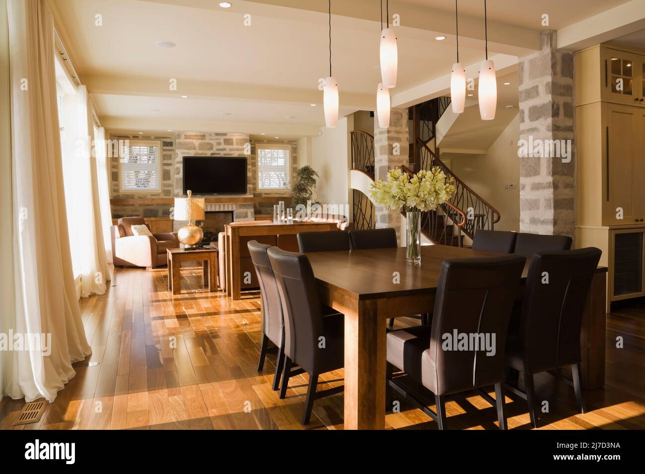 Wooden dining table and brown leather high back chairs in dining room