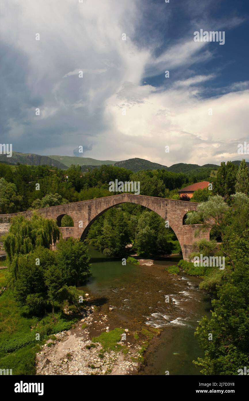 The graceful Pont Vell or Old Bridge over the River Ter at Sant Joan de les Abadesses, in Catalonia, Spain, is the product of repairs and rebuilds after earthquake and war damage, with the original 12th century structure transformed into a slender design said to be the lightest Gothic bridge on the Iberian Peninsula. Stock Photo