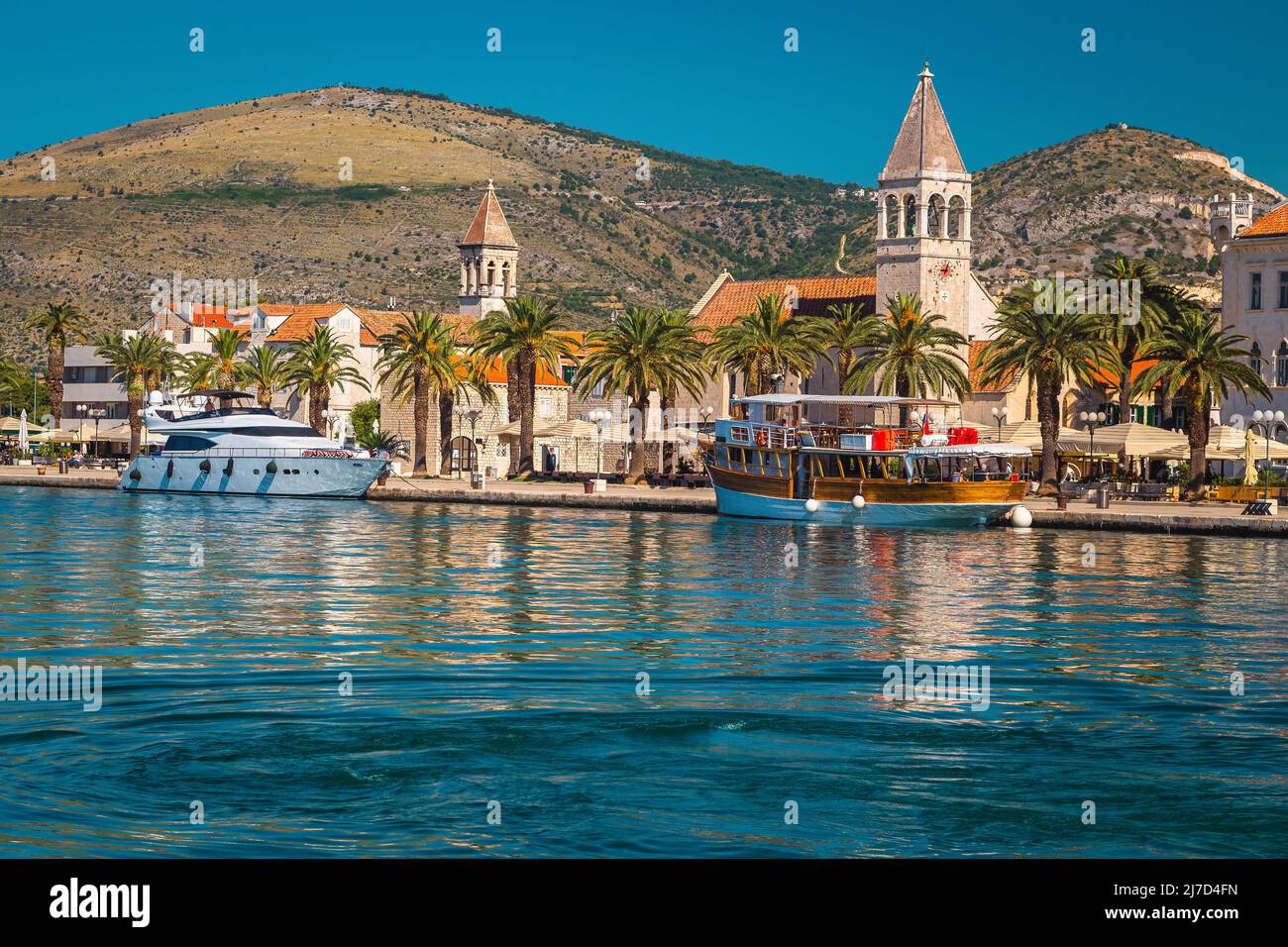 Amazing view with luxury yacht and old ship in the touristic harbor. Spectacular waterfront promenade with palms and street cafes, Trogir, Dalmatia, C Stock Photo