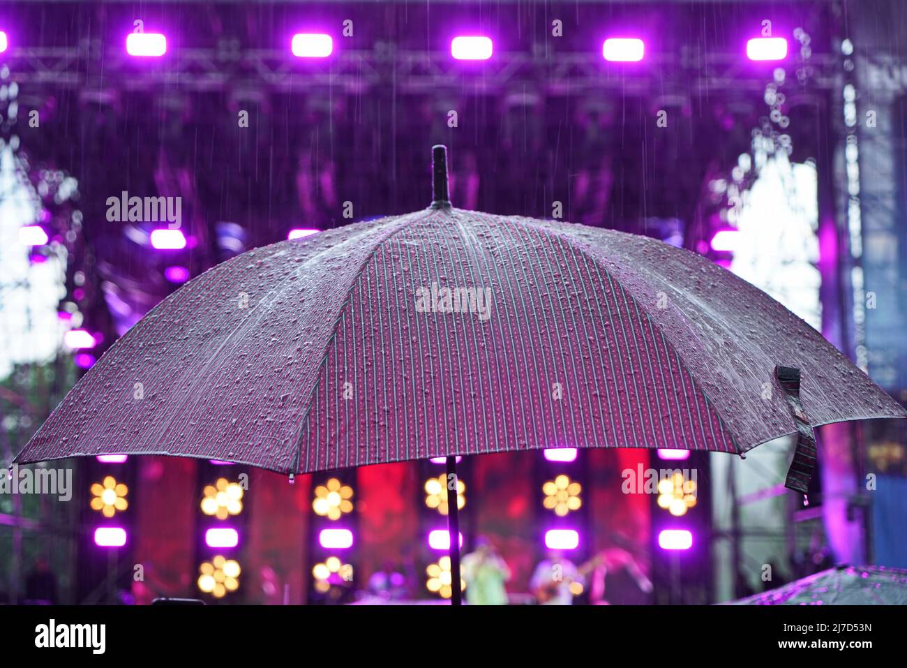 an umbrella wet from the rain during an outdoor event Stock Photo