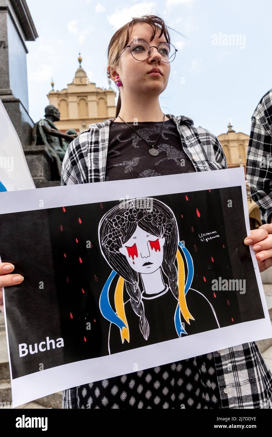 A Russian woman holds a placard 'Bucha' to protest Russian war on Ukraine at the Main Market Square in Krakow, Poland on May 8, 2022. Demonstration was organised by Russian community in Poland, very few Russians attended the demonstration. It is illegal to protest in Russian Federation itself. White-blue-white flag is Russian symbol of opposition to the 2022 Russian invasion of Ukraine and it symbolises Russia without the red colour, without the blood. (Photo by Dominika Zarzycka/Sipa USA) Stock Photo