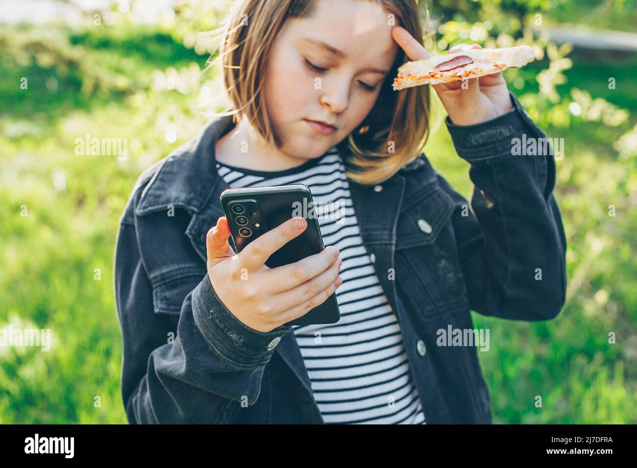Preteen girl holding phone, using cell phone for chatting with friends. Concept of modern technology Stock Photo
