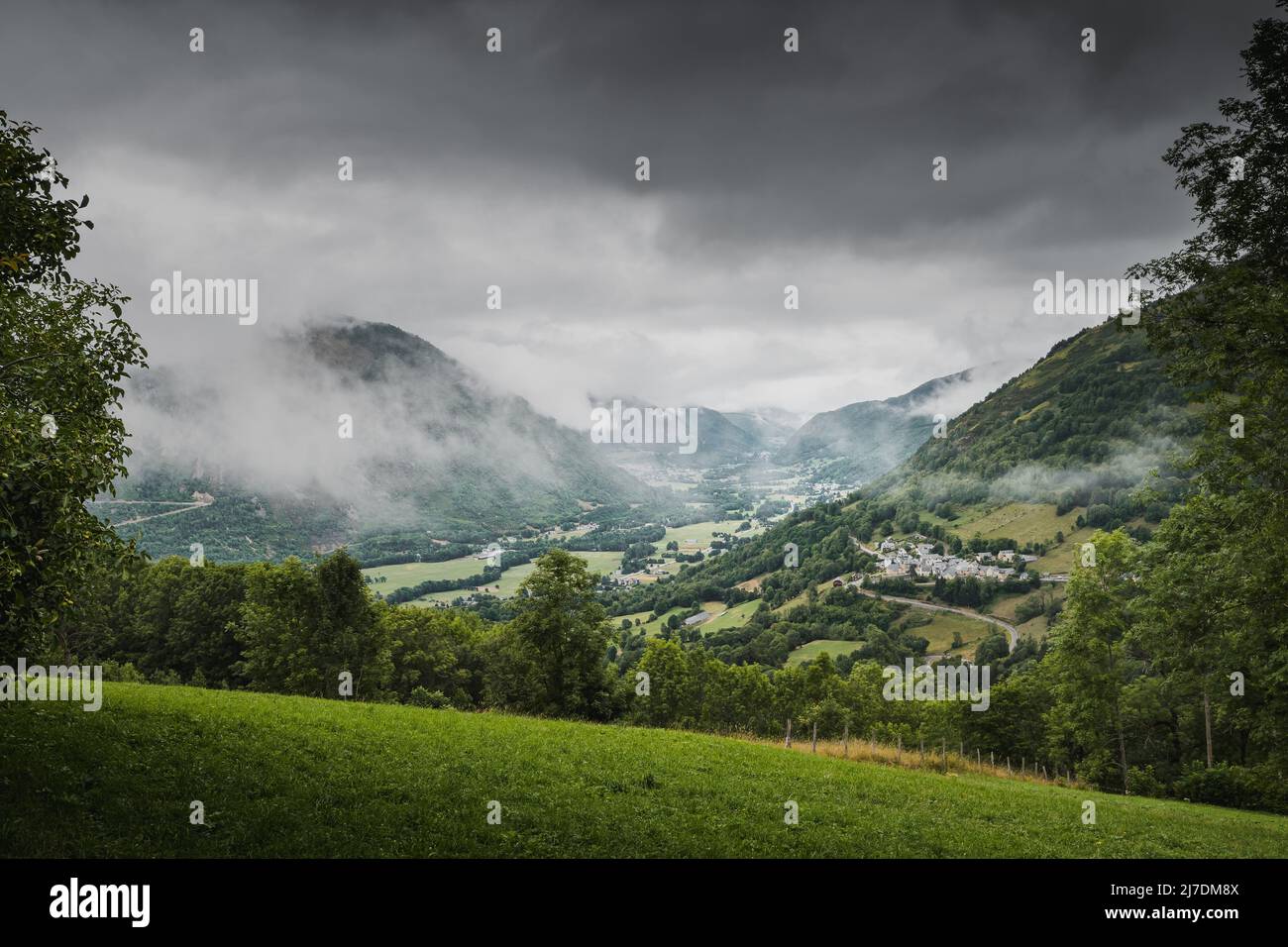 view of valley Aure in the french pyrenees mountains on a cloudy day with typical pyrenean village in altitude Stock Photo