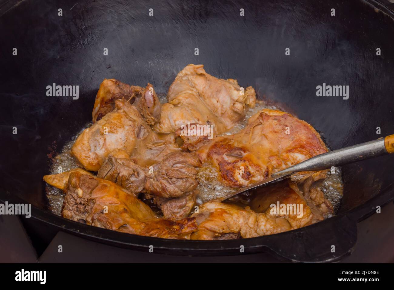 Process of cooking lamb meat for pilaf, pilau in huge cauldron Stock