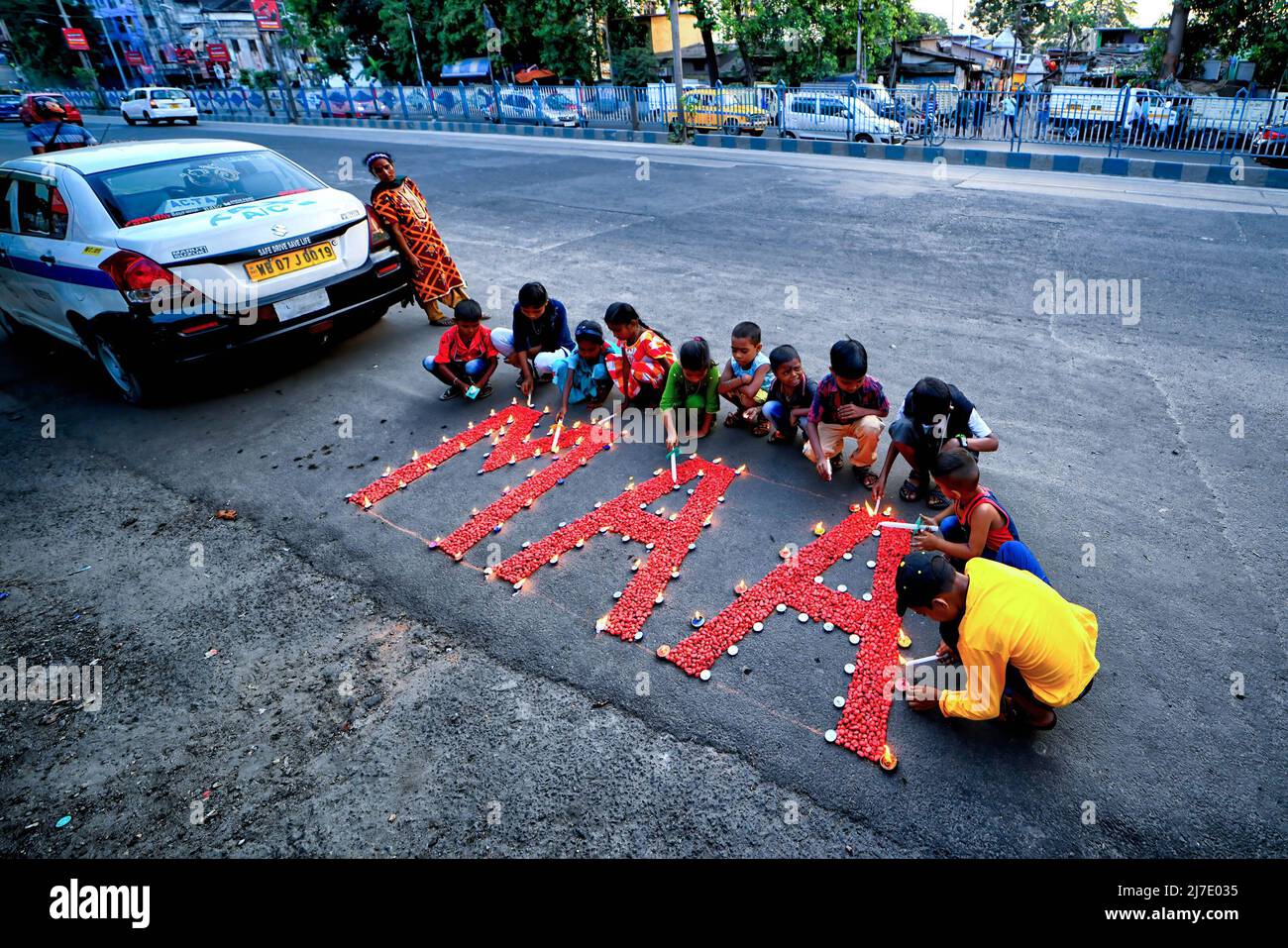 Kolkata, India 8 May 2022, Children light candles around the word