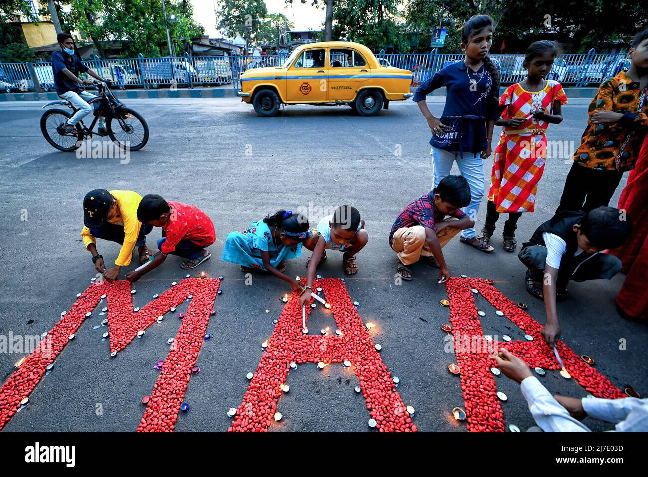 Kolkata, India 8 May 2022, Children light candles around the word