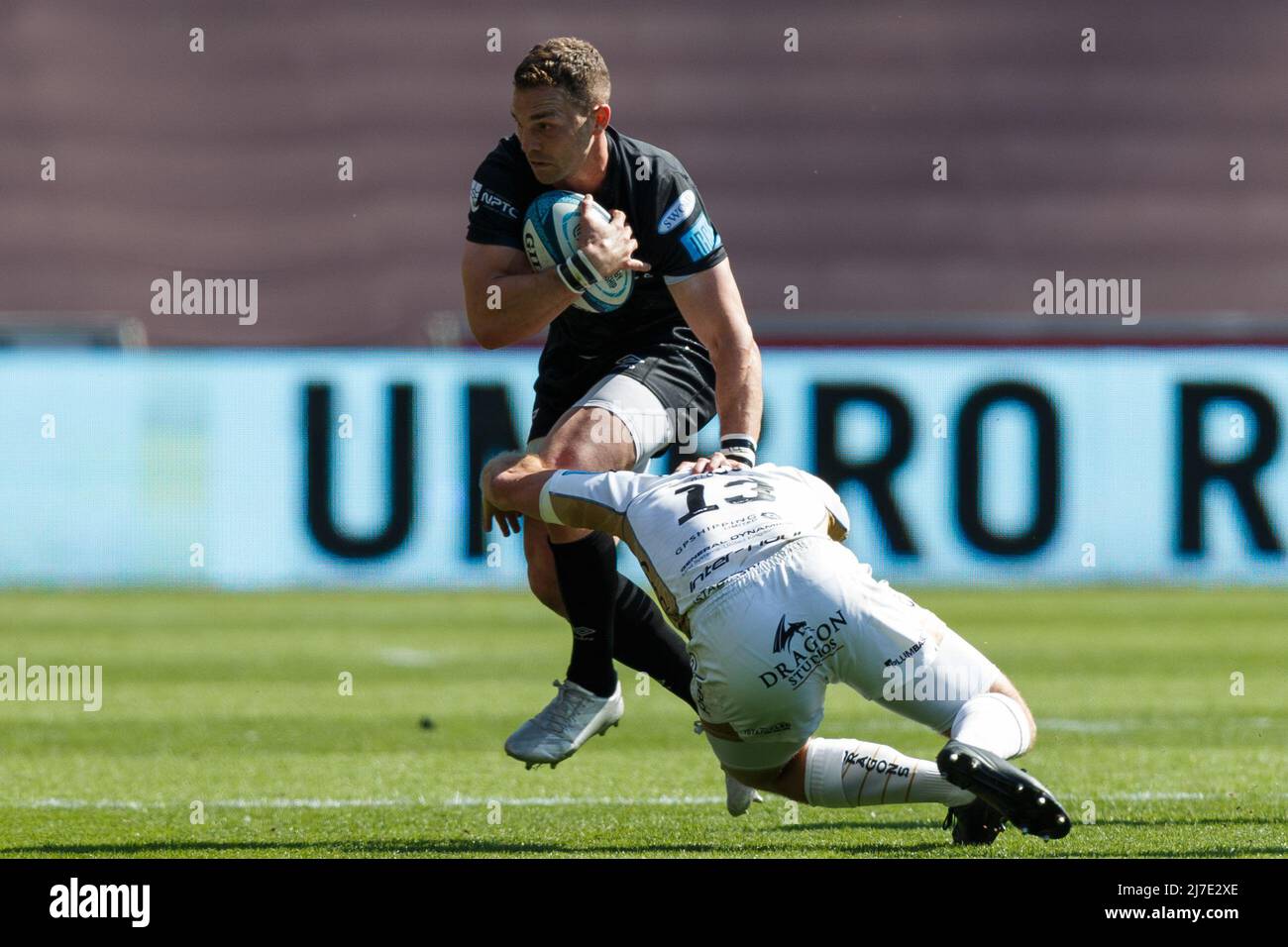 Swansea, UK. 8 May, 2022. George North of Ospreys is tackled by Adam Warren of Dragons during the Ospreys v Dragons United Rugby Championship Match. Credit: Gruffydd Thomas/Alamy Stock Photo