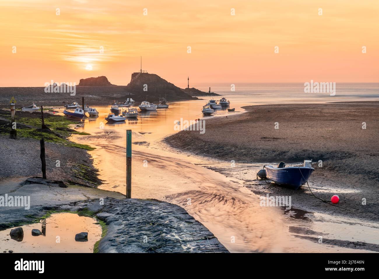 A hazy end to the day as the sun sets over the picturesque breakwater at Bude in North East Cornwall. Stock Photo