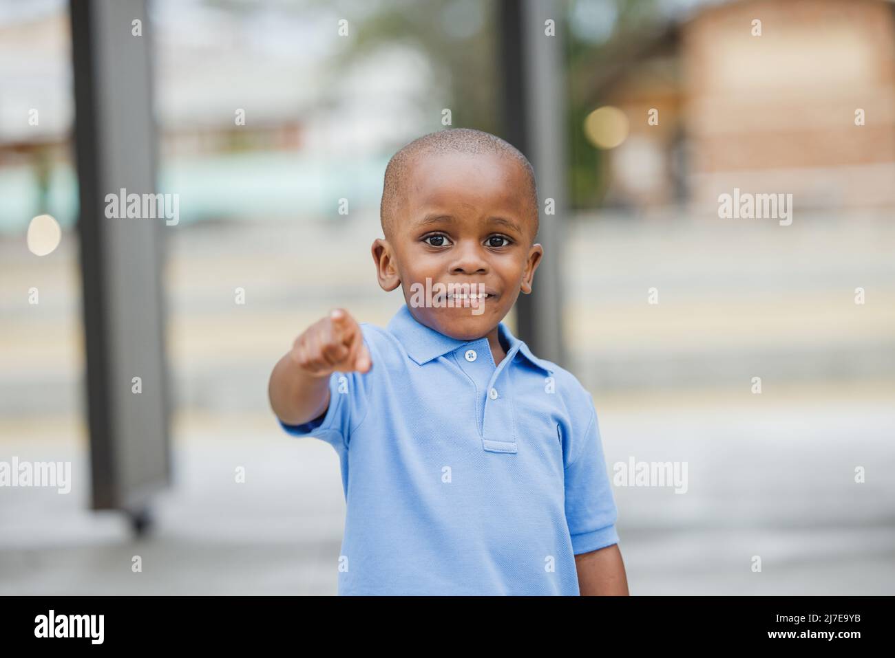 A little boy standing outside and pointing Stock Photo