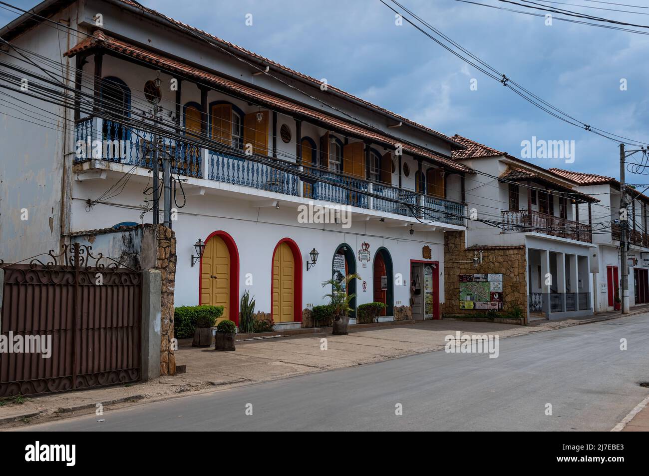 Many small business running in a big colonial building at Inconfidentes street, nearby Tiradentes historical center and under heavy clouded sky. Stock Photo