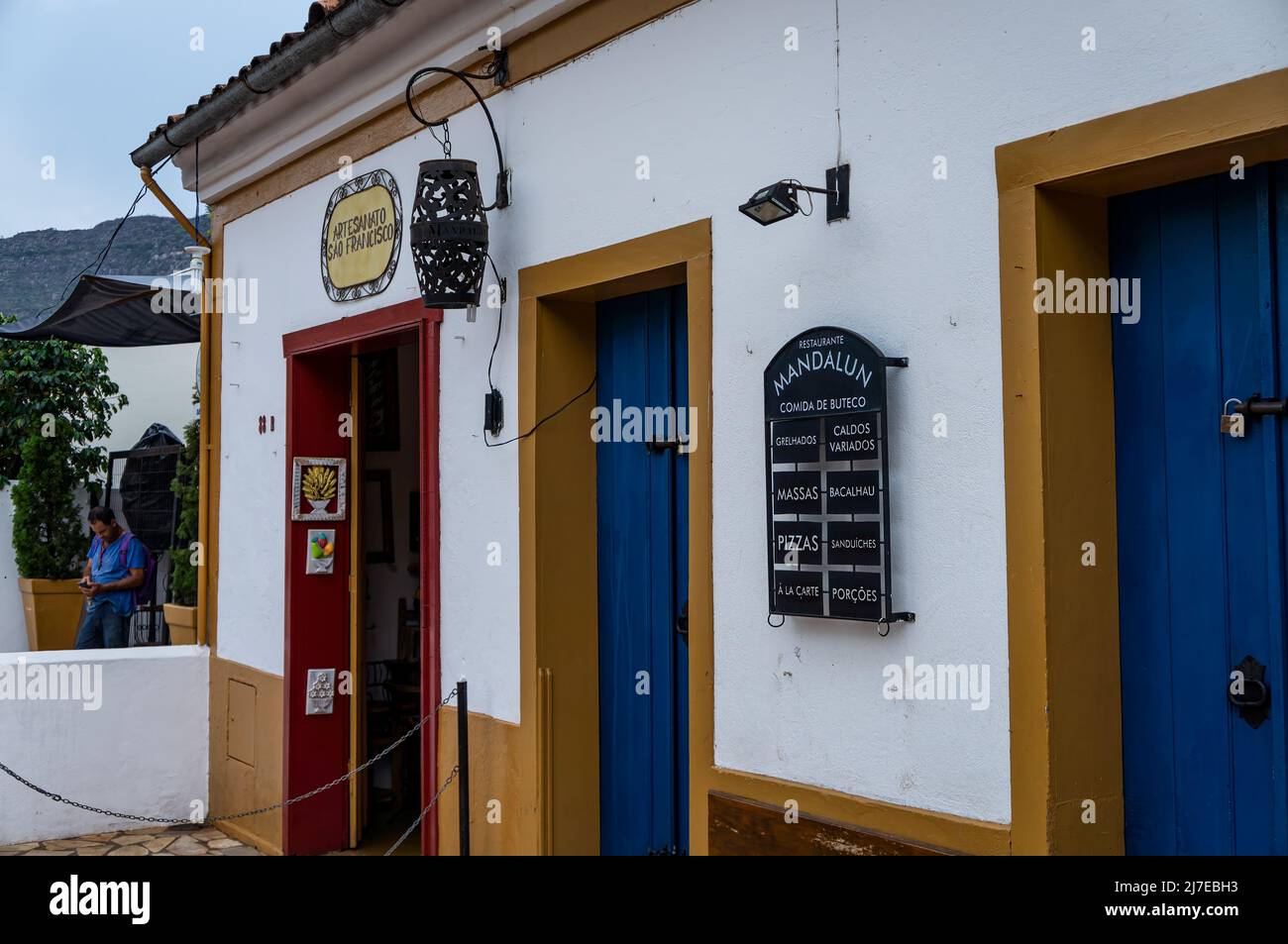 Entrance doors of Sao Francisco crafts shop (left) and Mandalun bar food restaurant (right). Local small business located at Silvio Vasconcelos street Stock Photo