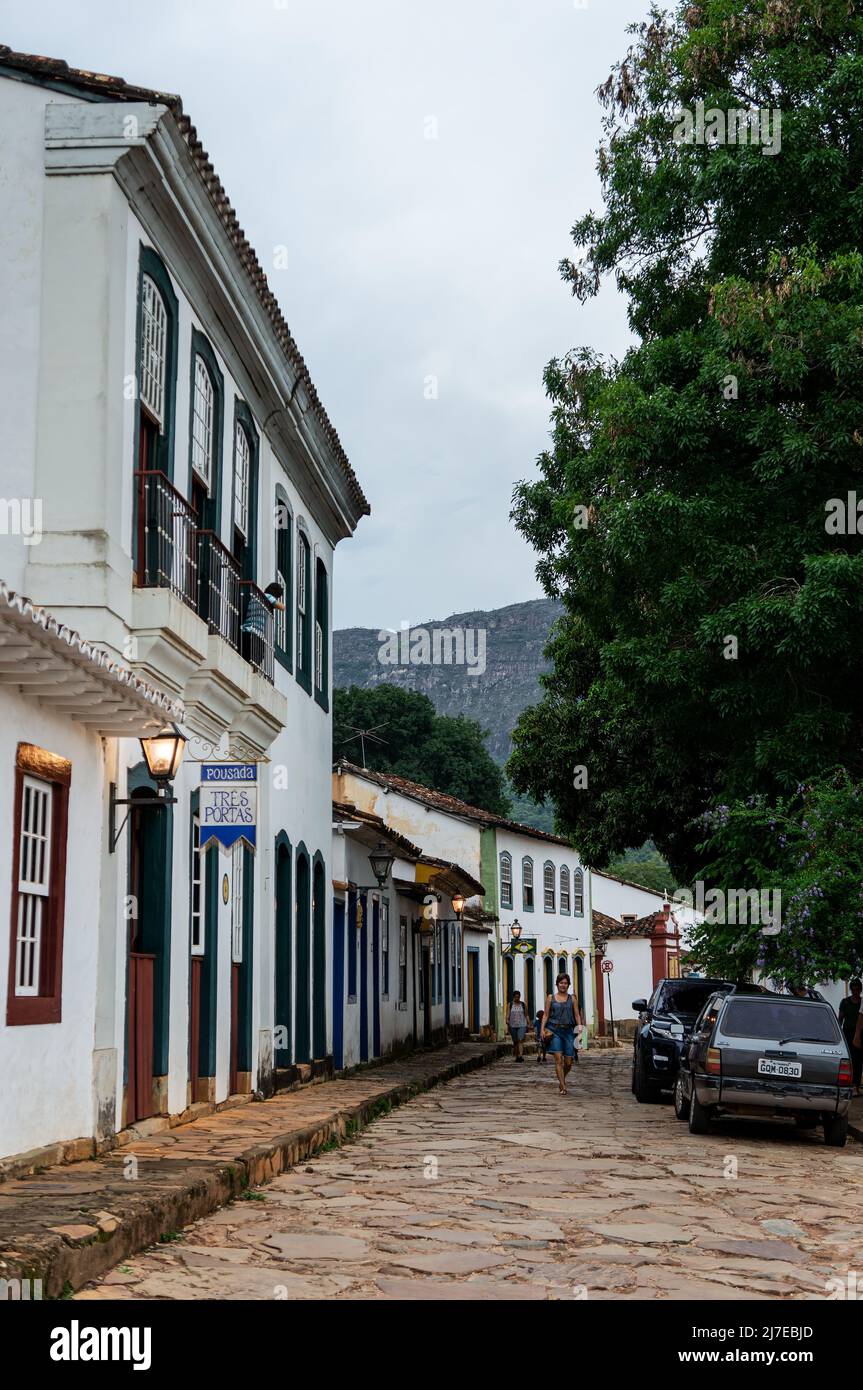 View of the east end of Direita street with a row of colonial houses side by side in Tiradentes historical center under clouded sky. Stock Photo
