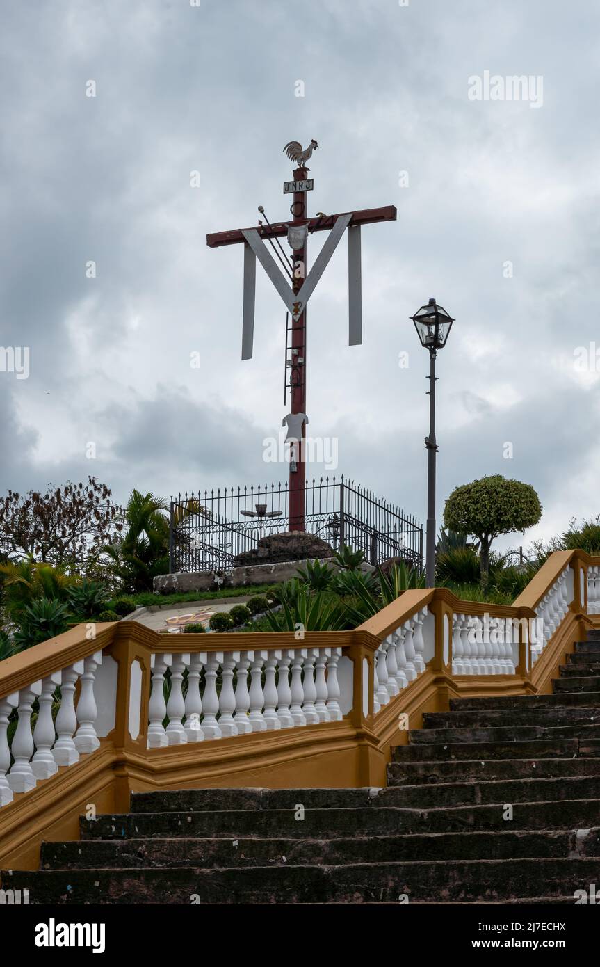 A religious cross located at the side of the stairway of Nossa Senhora das Merces church in the historical center and under overcast sky. Stock Photo