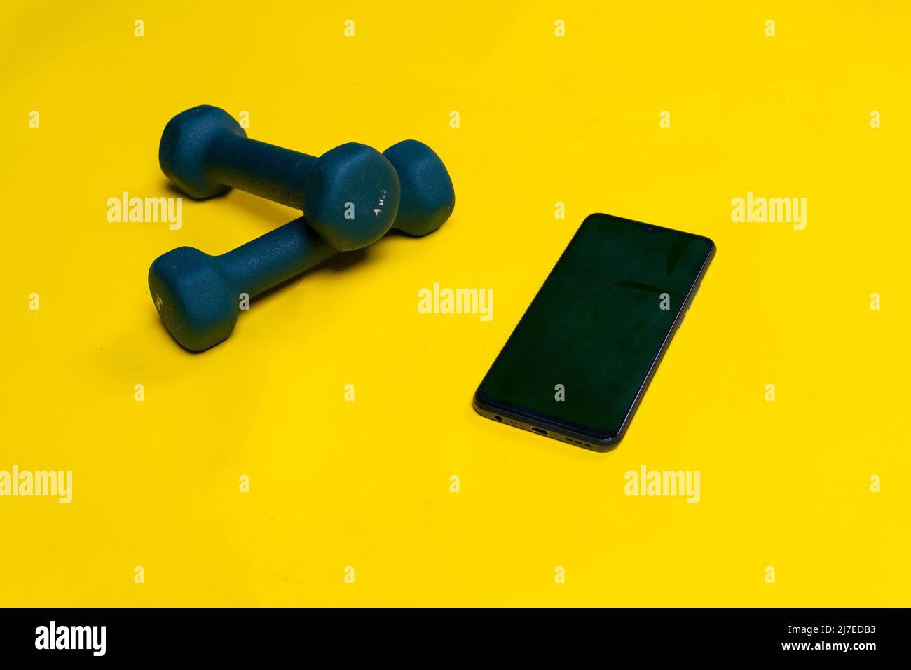 With background space Blue phone dumbbells yellow text for a on space background, for cast exercise for black and bell gym, kettle color. Wellbeing kg Stock Photo