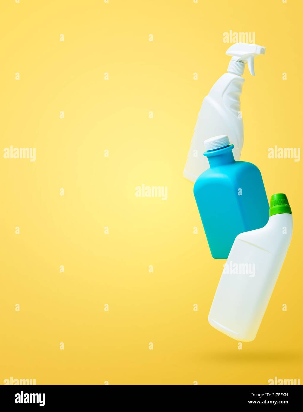 Levitation, falling in air blank household chemical bottles for cleaning the house. Isolated on yellow background. Plastic packaging. Toilet cleaner, detergent sprayer, soap. New brand product mockup Stock Photo