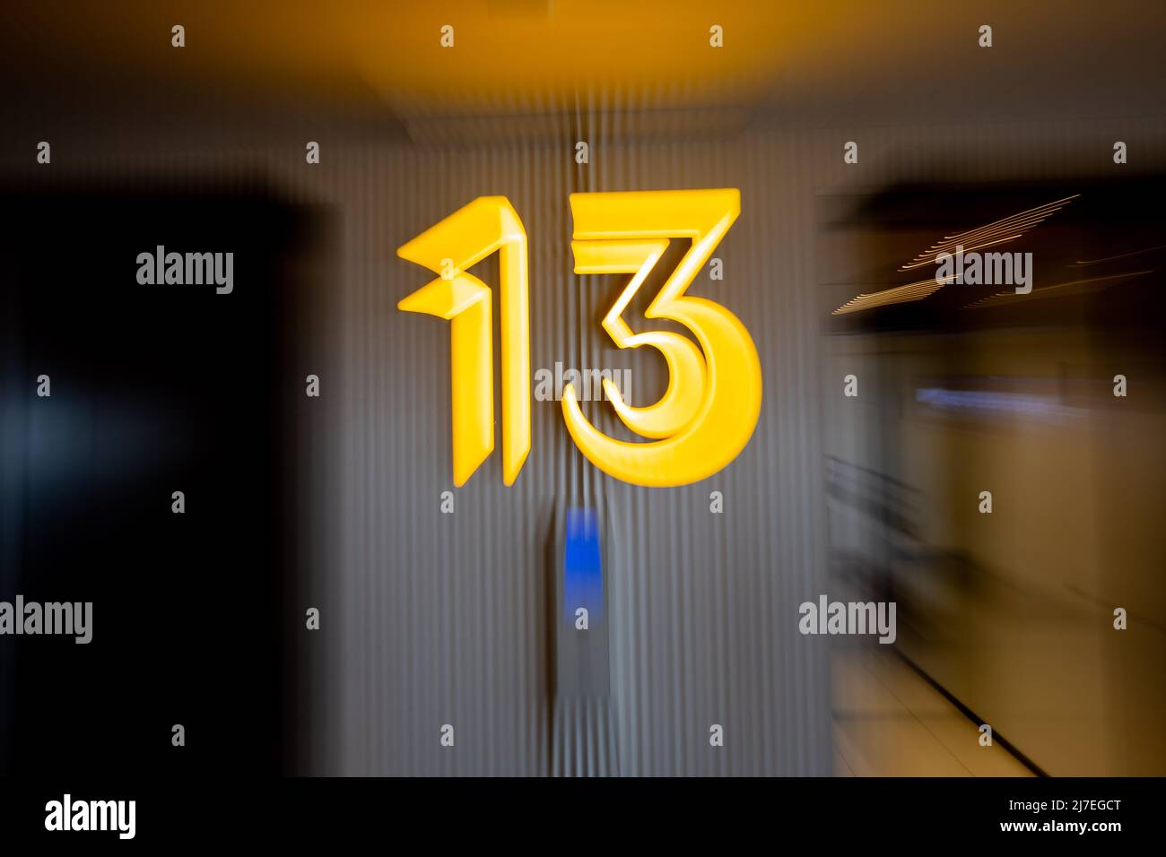 28 April 2022, Berlin: The number 13 hangs on the elevator on the 13th floor in a building. (Posed scene, wipe effect by zooming) Photo: Christoph Soeder/dpa Stock Photo