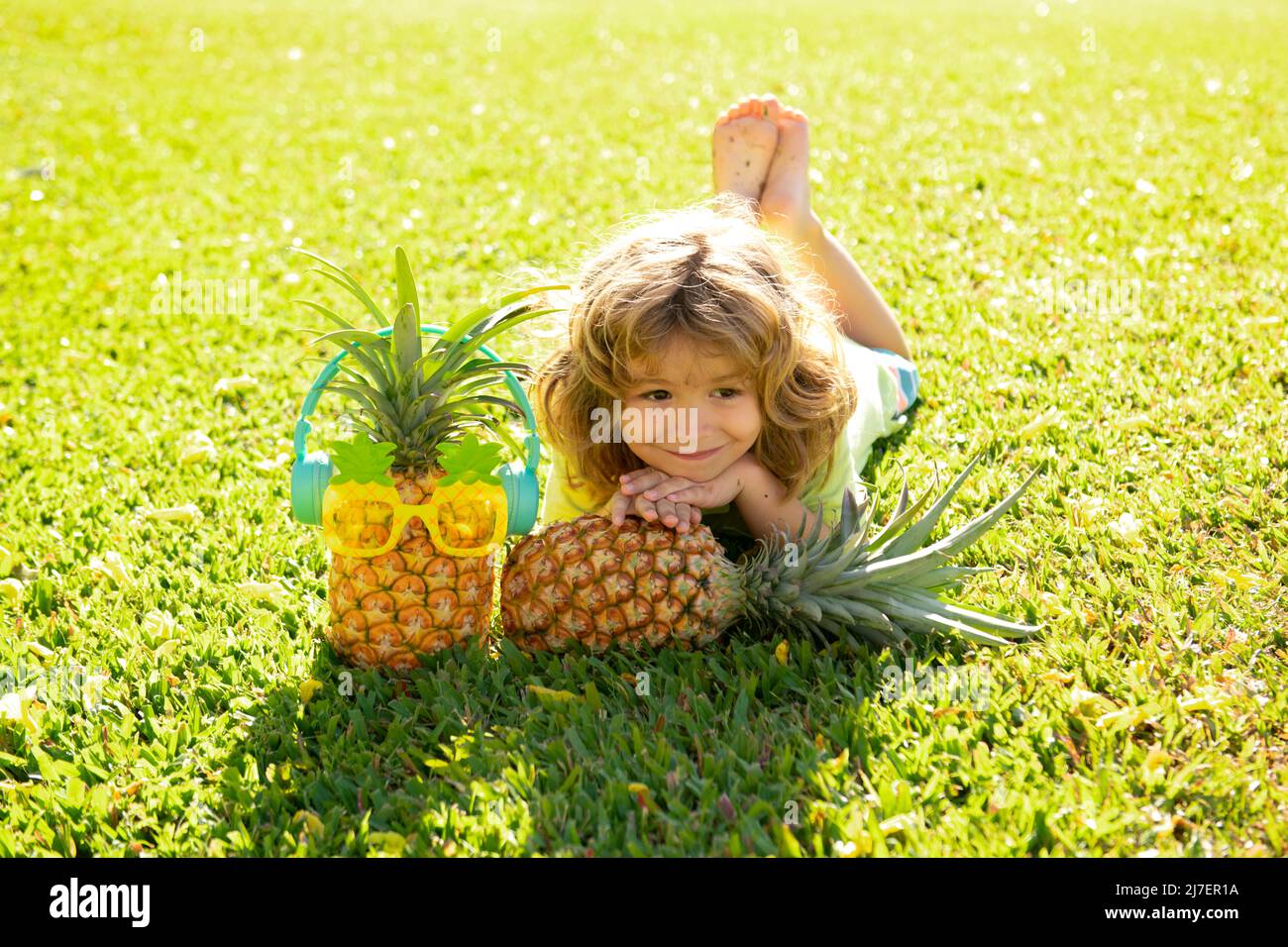 Pineapple kid boy and pineapples on summer vacation. Stock Photo