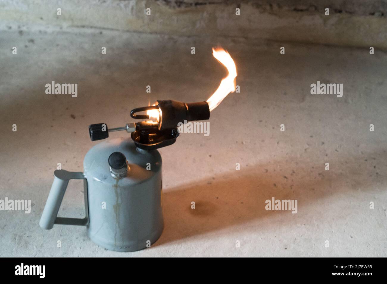 Gasoline blowtorch with a burning fire, the use of a blowtorch in