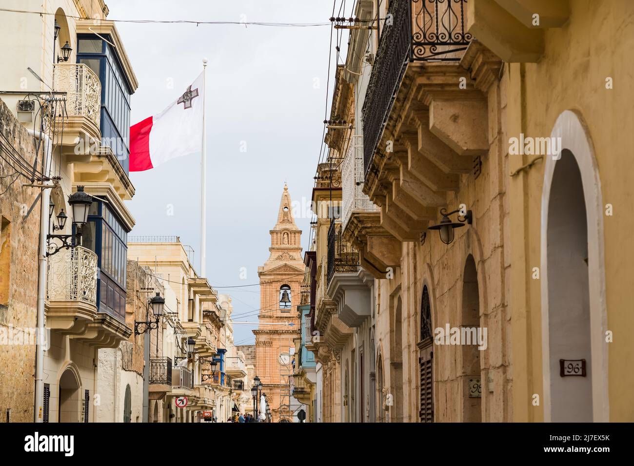 Malta flag flying high above a street in Mellieha, Malta in May 2022