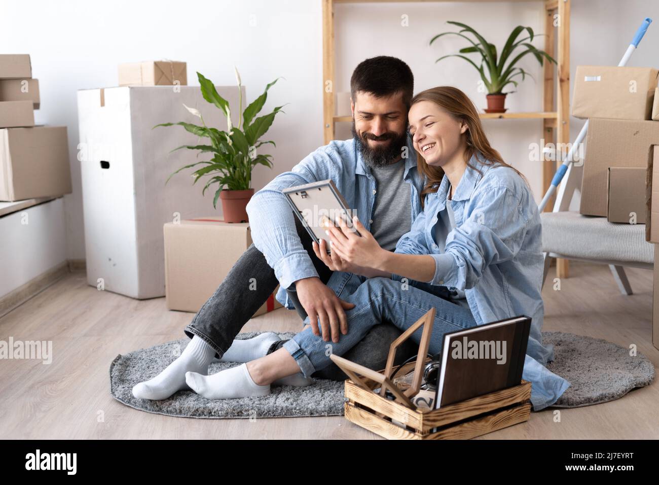 happy young couple sit on floor in casual clothes hugging looking at ...