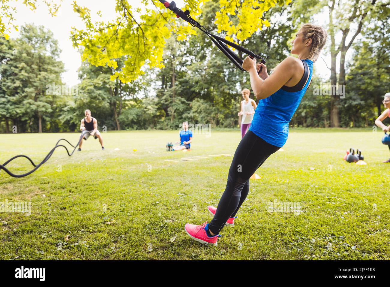 Young woman working out with elastic band in park Stock Photo