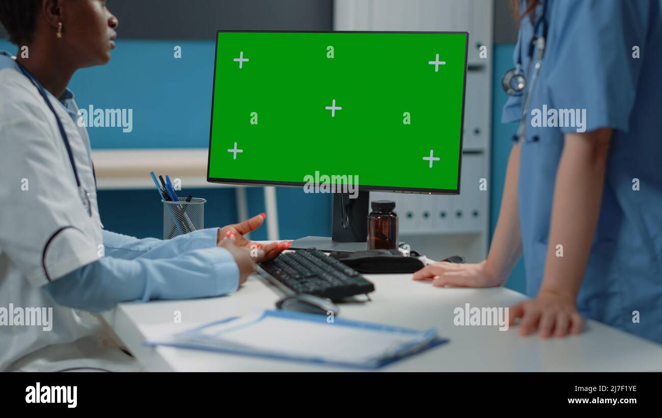 Close up of computer with horizontal green screen on desk while doctor ...
