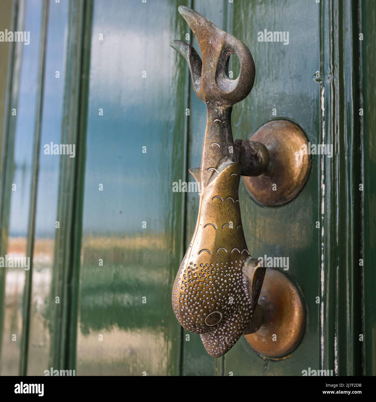 Fish door knocker on a shiny green door in Malta seen in April 2022