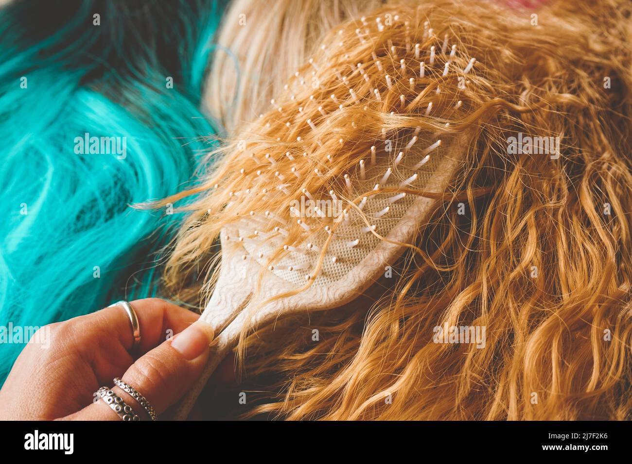 Close up of a brush brushing a colored wig as a cosplayer are stylize a wig for a costume Stock Photo