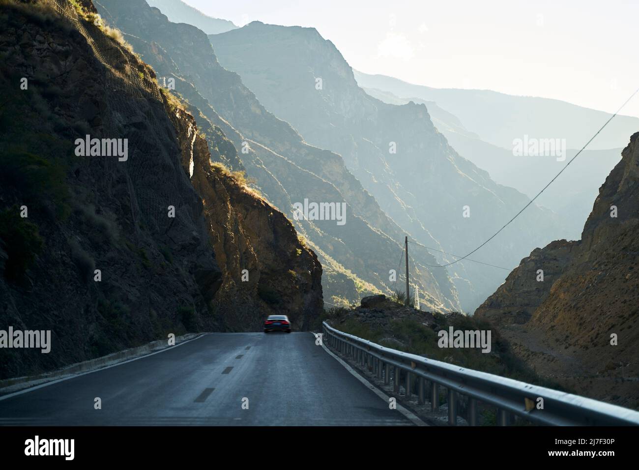 car running on highway through the rocky mountains in sichuan province, china Stock Photo