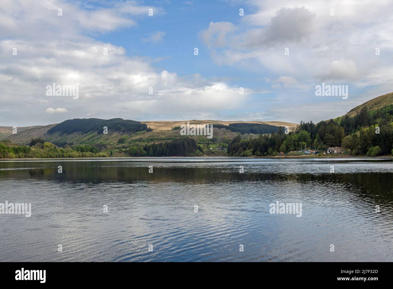 Looking across Pontsticill Reservoir and to the boathouse in the Central Brecon Beacons on a sunny May day Stock Photo