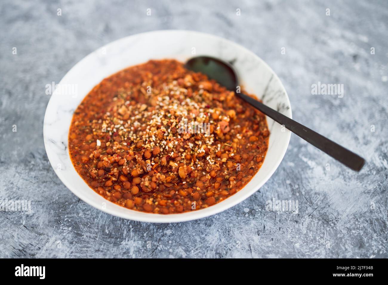 vegan lentil and couscous ragu with herbs and dukkah as topping
