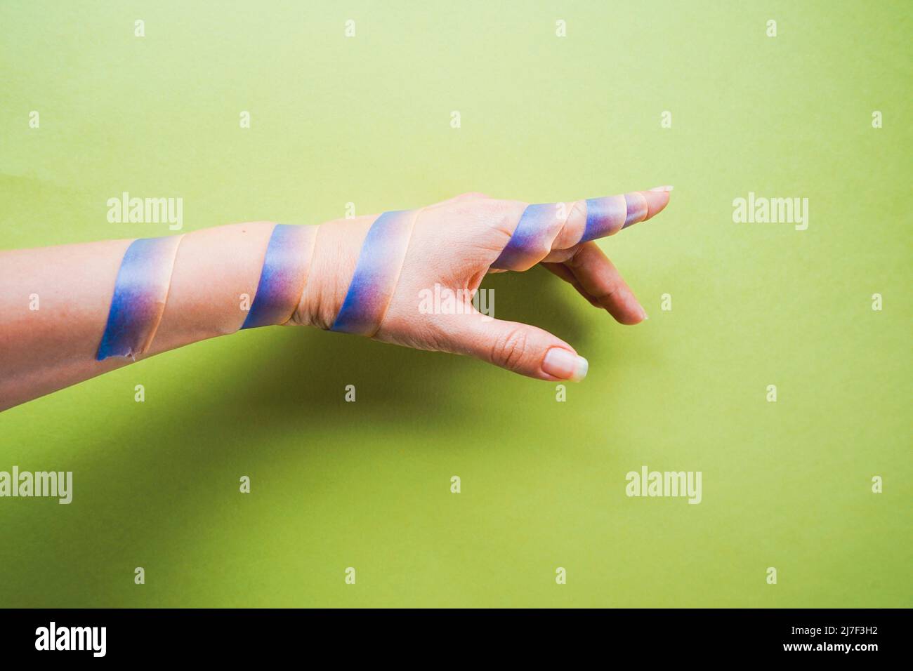 Conceptual image of a washi tape surrounded a human arm and obligate it to point in an only one way Stock Photo