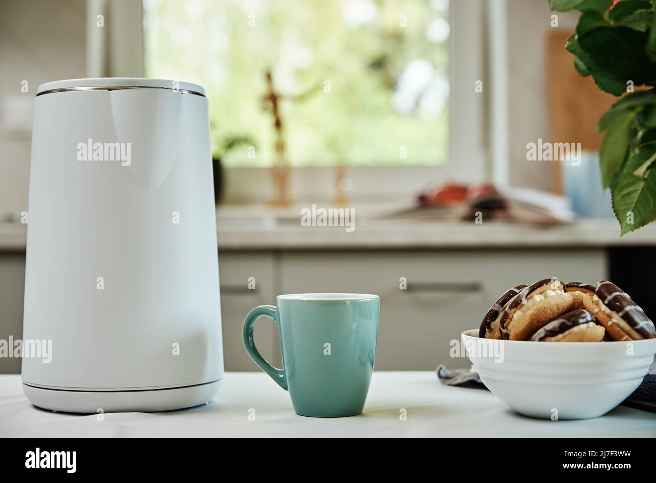 Modern electric kettle and cups of tea on white wooden table in kitchen.  Space for text Stock Photo by ©NewAfrica 317399329