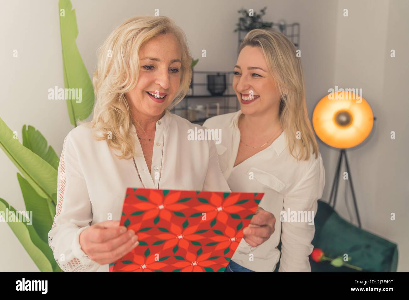Happy mature mom receiving a gift from her grown-up daughter. High quality photo Stock Photo