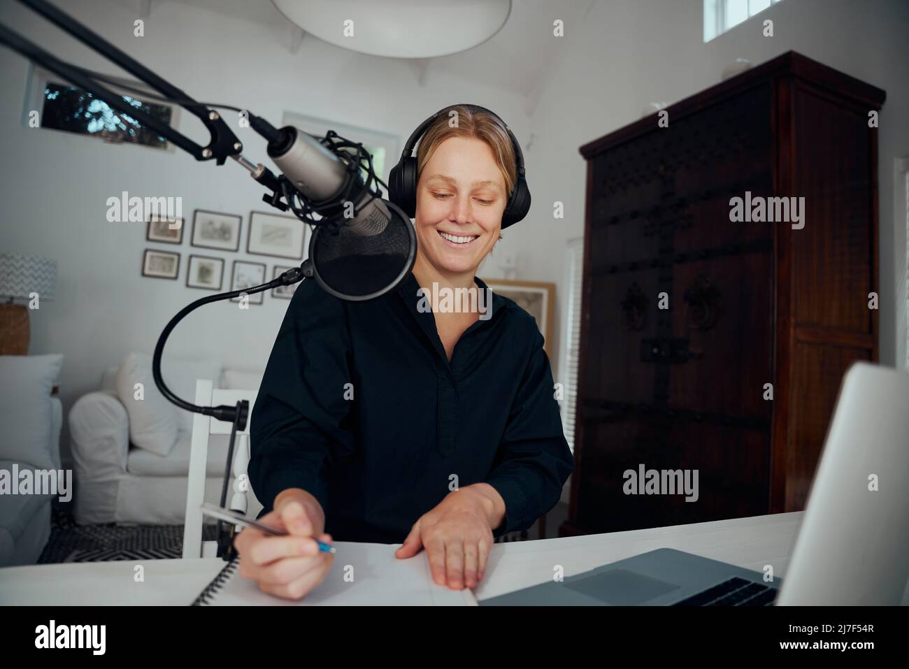 Caucasian female podcaster working from home writing script for recording  Stock Photo