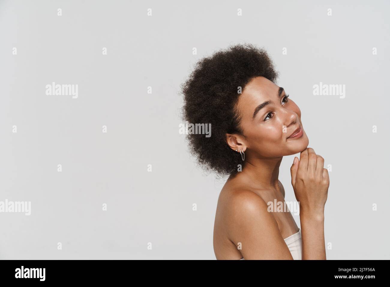 Black brunette woman smiling and looking upward isolated over white ...