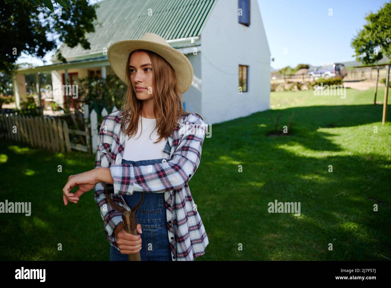 Caucasian female farmer standing outdoors leaning on pitch fork  Stock Photo