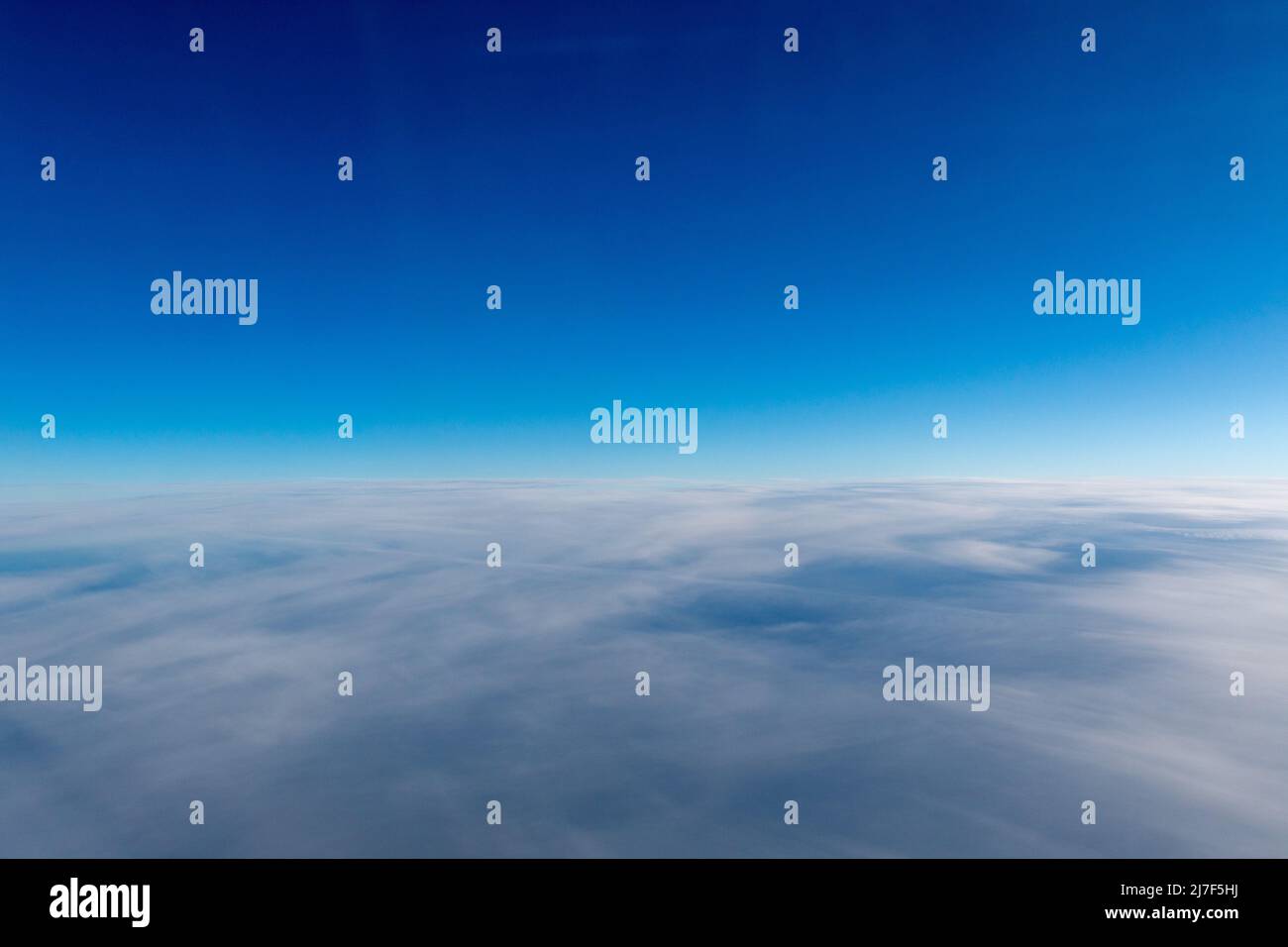 A view of a blue sky above white clouds. Stock Photo