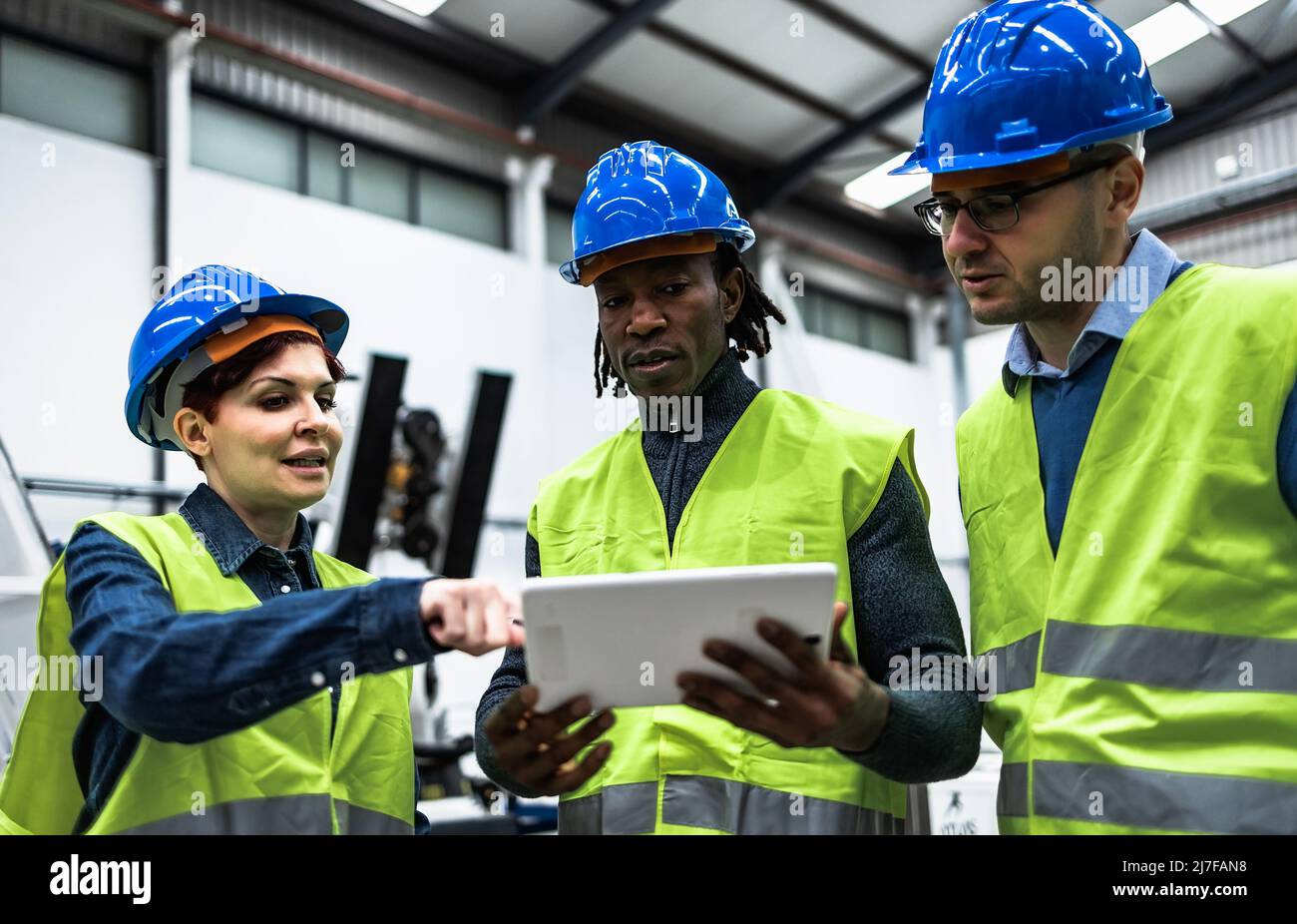 Team of engineers working in robotic factory while analyzing the ...