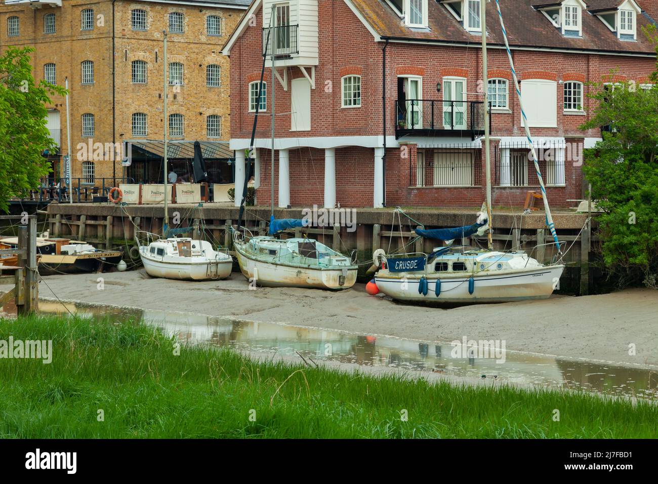 Boats on river Medway at low tide in Faversham, Kent, England. Stock Photo