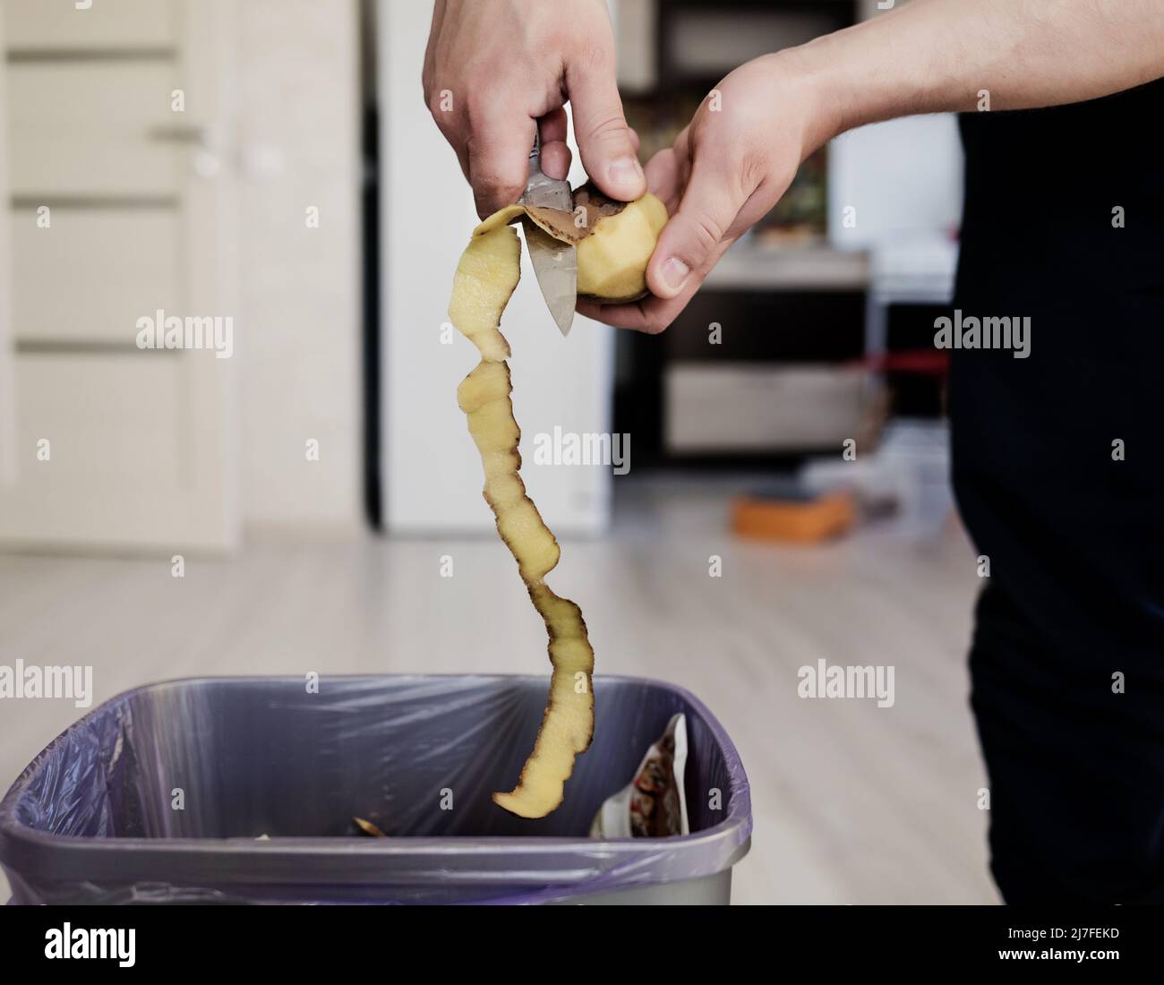 chef peeling potatoes. closeup peeling off potato with knife Stock