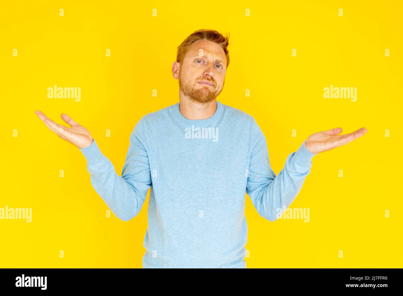 Young adult man showing doubt expression over isolated yellow background Stock Photo