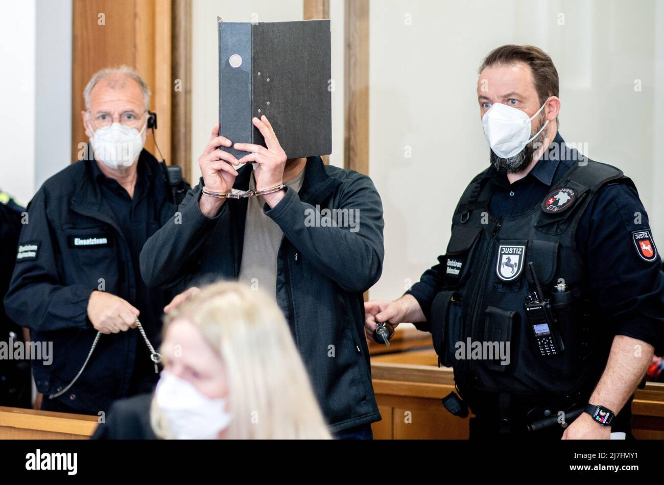 Oldenburg, Germany. 09th May, 2022. The defendant covers his face with