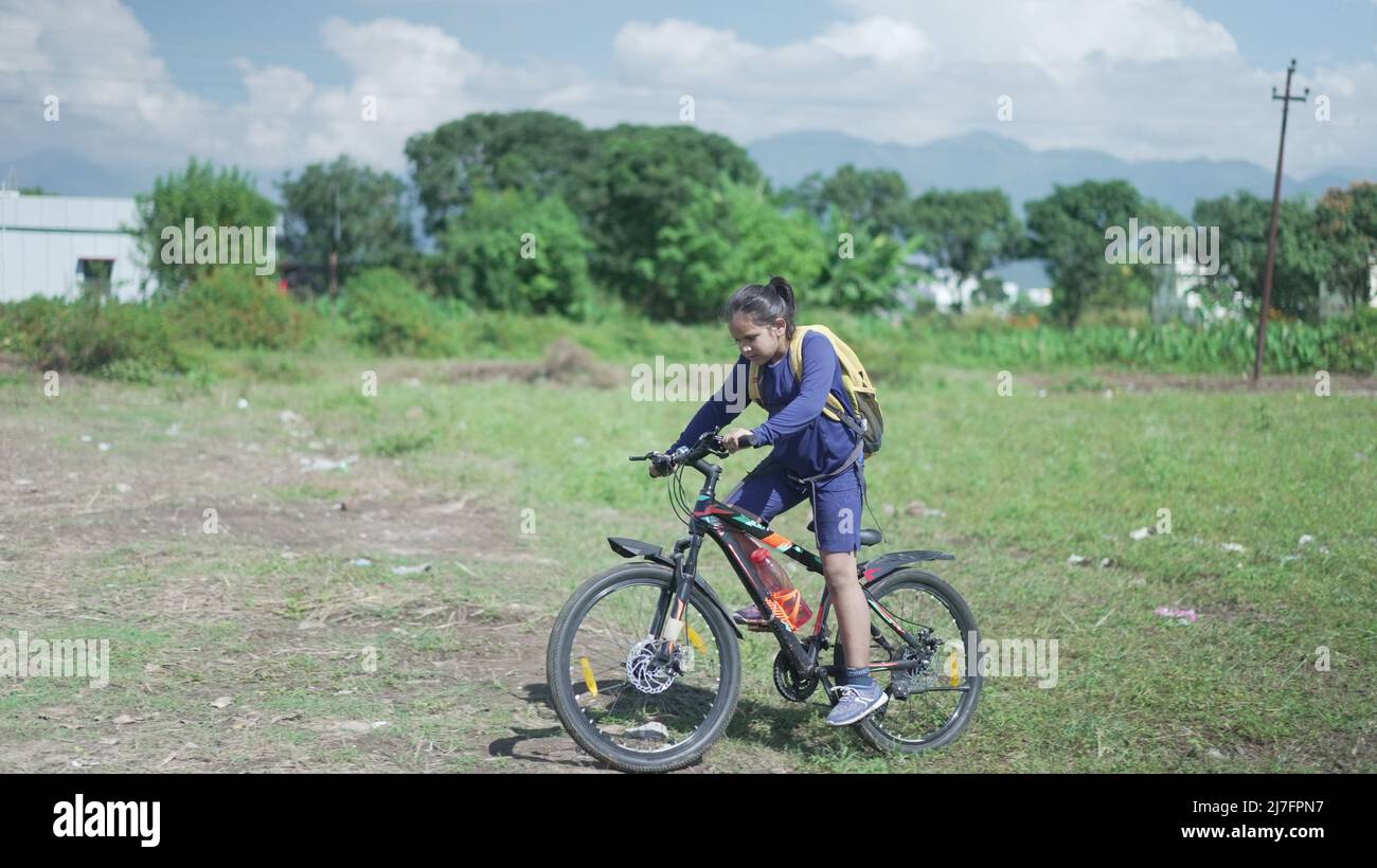 An Indian Kid cycling on a road, near a sugarcane field in a rural area of Uttarakhand, India. Physical fitness of an Indian boy. High-quality image. Stock Photo