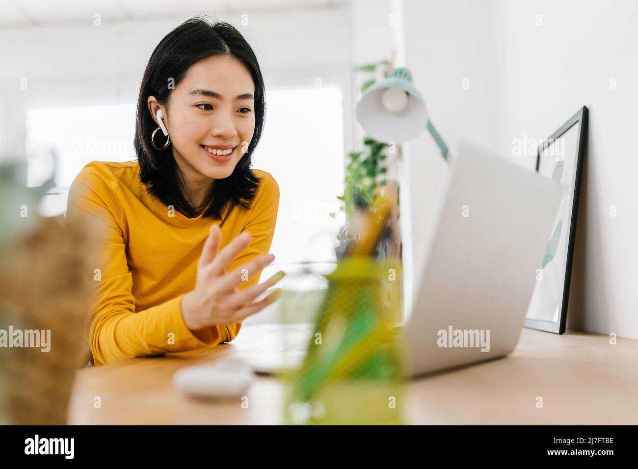 Young asian woman having a video call on her laptop while working from ...