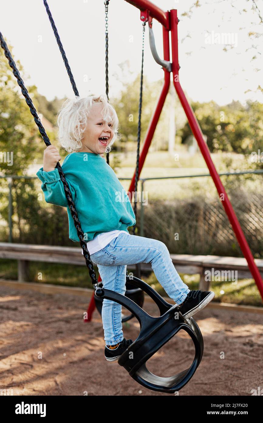 Happy child swinging Stock Photo