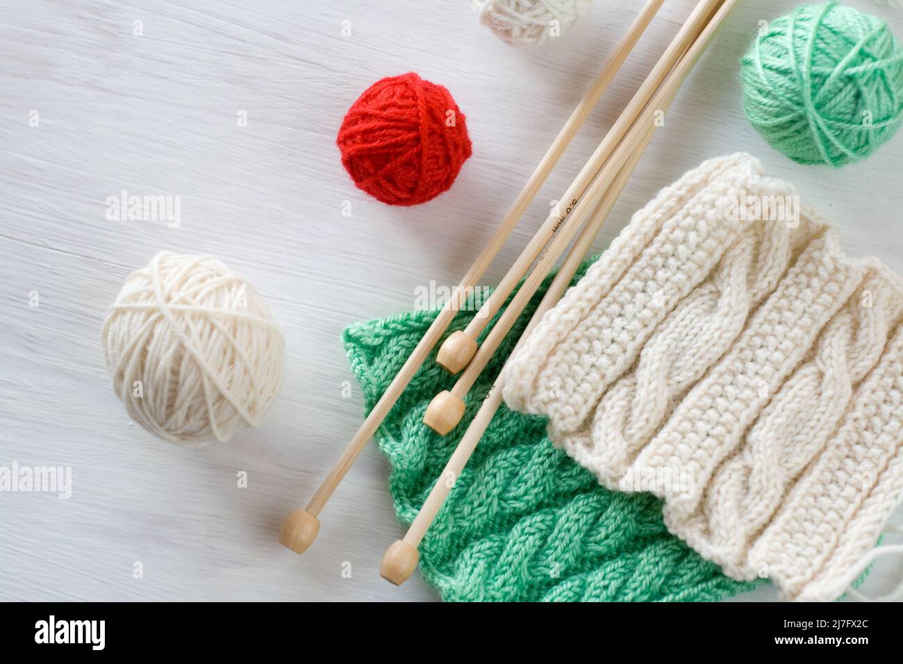Two bright patterns, yarn balls and needles for knitting wooden white ...
